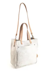 Bolso tipo tote de cuero con acabado texturizado en tono blanco desgastado. Cuenta con doble asa de mano y una correa larga ajustable y extraíble en color tostado. Presenta un bolsillo frontal externo y herrajes metálicos.