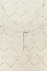 Top color crema de punto calado, con escote redondo y sisas.