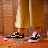 Championes Vans Old Skool color negro con la franja lateral blanca y suela blanca.