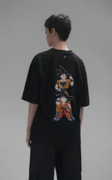 Remera negra de corte oversize con cuello redondo y mangas cortas. Presenta un estampado central de Goku y Goten en sus versiones de Dragon Ball.
