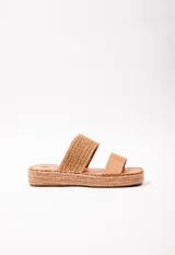 Sandalia con doble tira en el empeine, una de cuero color tostado y otra tejida en rafia. Plataforma de yute de 3.5 cm de alto.