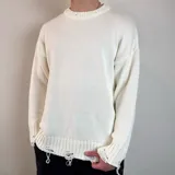 Sweater de tejido de punto color blanco, con diseño de cuello redondo y detalles de roturas desgastadas en el cuello, puños y ruedo.