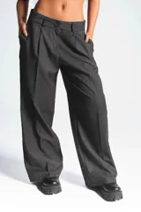 Pantalón de vestir gris oscuro, de corte palazzo, con pinzas en la cintura y bolsillos laterales.
