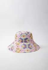 Gorro tipo bucket hat estampado con flores y hojas en tonos verde y celeste sobre fondo blanco. Es reversible.