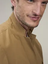 Blazer color marrón claro, de corte clásico, con solapas de muesca, cierre de dos botones, bolsillo en el pecho y bolsillos laterales con solapa.