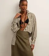 Pollera midi de corte sastre color verde militar, confeccionada en algodón, con cintura ancha y traspase falso con costura aparente.