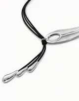 Collar corto con tres tiras de cuero negro, un dije central plateado con forma de ala de hoja o gota alargada y tres colgantes en forma de gota en los extremos.