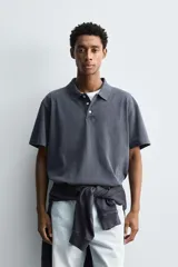Polo de manga corta con cuello solapa y cierre frontal de tres botones. Presenta un diseño de corte relajado con acabado de efecto lavado.