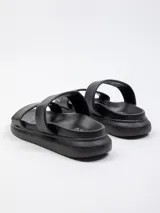 Sandalia baja con plataforma de 2 cm, presenta dos tiras anchas blancas sobre la capellada y base de color negro.