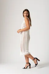 Vestido blanco de algodón con tejido calado y flecos en el ruedo.