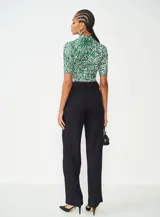 Blusa de mangas cortas con cuello alto y estampado animal print en tonos verde y blanco.