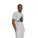 Remera de algodón gris con cuello redondo y mangas cortas. Presenta un estampado grande del logo de Adidas en color negro en el centro del pecho.