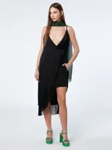 Vestido corto negro con breteles finos, escote en V, corte irregular con flecos y un bolsillo lateral.