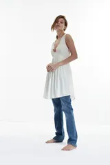 Vestido corto blanco con escote en V y detalle de puntilla en el escote.