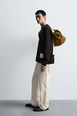 Sudadera negra de corte relaxed fit, confeccionada en tejido técnico interlock de algodón con elasticidad. Presenta cuello redondo, manga larga y una etiqueta aplicada en el bajo. Los acabados son en rib.