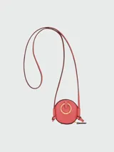 Monedero circular de la línea Épure de Longchamp, en color verde menta, con cierre de solapa y correa larga ajustable para llevar cruzado.