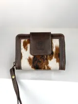 Mini billetera de cuero con diseño combinado de cuero liso marrón y cuero con pelo vacuno estampado. Cuenta con cierre de solapa con broche magnético y logo de búho grabado, además de una correa de muñeca extraíble.