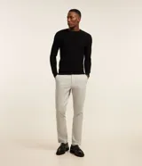 Pantalón slim de sastrería de color gris claro, confeccionado en sarga de algodón con elastano, con cierre frontal de botón y cremallera, y bolsillos.