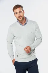 Buzo tejido de algodón gris claro melange, de cuello en V y manga larga, con detalle de bordado pequeño en el pecho y aplique metálico en el borde inferior.