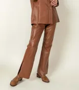 Pantalón de cuero ovino italiano de corte recto, con diseño de cinco bolsillos y cierre frontal con botón metálico.