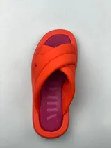 Sandalias de plataforma con diseño de tiras cruzadas acolchadas en color verde y plantilla en color naranja.
