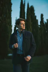 Campera marrón de gabardina de algodón con cuello clásico, cierre frontal con doble carro, bolsillos tipo plaqué con tapa y botón en laterales y pecho.