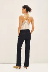 Pantalón sastrero de denim color azul oscuro con costuras a contratono. De corte recto y tiro medio-alto, con cierre metálico y gancho sastrero en el frente.