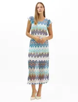 Vestido midi confeccionado en tejido de punto calado, con patrón geométrico en zigzag en tonos blanco, marrón, tostado y azul. Presenta escote a la base, mangas cortas con volados en los hombros, silueta recta y forro interior a tono. Incluye un cinturón fino con hebilla metálica.