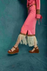 Pollera midi negra con detalle de cuero calado y flecos blancos en el ruedo.