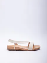 Sandalia baja de mujer color blanco hueso, con dos tiras anchas sobre el empeine y tira elástica de sujeción en el tobillo. La base es de color suela natural.