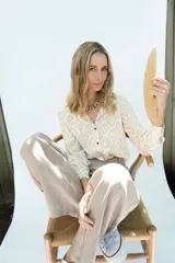 Camisa de fibrana de estilo clásico, con estampa ikat en tonos beige y blanco, cuello camisero, mangas largas y botones de coco en la parte frontal.