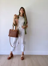 Cartera bandolera de cuero color tostado, con correa larga regulable, bolsillo frontal y forro de tela.