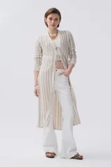 Sacón largo de tejido de punto calado en color crudo y beige, con mangas largas y corte recto.