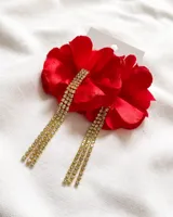 Par de caravanas con forma de flor roja y flecos de strass dorados.