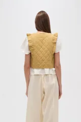 Chaleco corto de algodón con diseño capitoneado, cuello redondo y volados en los hombros.