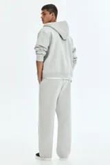 Pantalón deportivo en felpa pesada de mezcla de algodón con interior cepillado suave. Modelo de corte holgado con cintura elástica revestida, cordón de ajuste y bolsillos laterales.
