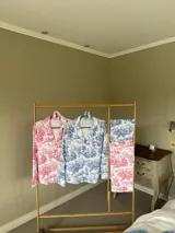 Pijama de algodón estampado con diseño toile de jouy, compuesto por una camisa de manga larga con botones y pantalón recto con elástico en la cintura.