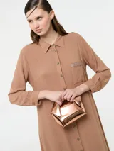 Vestido camisero largo color rojo, confeccionado en lino y viscosa, con cartera de botones delanteros centrales y bolsillo delantero superior con terminación de galón metalizado.