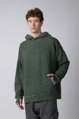 Buzo canguro de corte oversize en color verde con efecto de teñido desgastado. Cuenta con capucha, bolsillo frontal tipo canguro y puños acanalados.