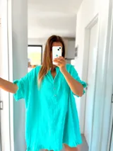 Túnica turquesa de lino con cuello mao, mangas cortas y ruedo desflecado.