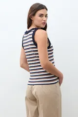 Top sin mangas a rayas horizontales en tonos azul marino, blanco y marrón, con detalle de volados en el cuello y las sisas.