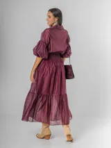 Falda larga confeccionada en organdí de algodón italiano color bordó. Presenta una cintura ancha elastizada con técnica de nido de abeja y un diseño con volado en el ruedo que aporta movimiento.