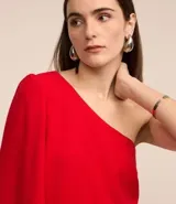 Blusa roja de crepé con un solo hombro descubierto y manga 3/4 abullonada.