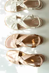 Sandalias chatitas de cuero en tono nude, con diseño de tiras cruzadas en el empeine y elástico en el talón para mayor ajuste. Presentan una plantilla acolchada y detalles en cuero charolado en la parte posterior.