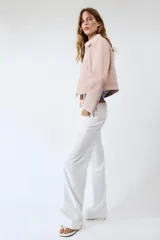 Chaqueta rosa de cuello solapa y manga larga, con cierre frontal y detalles de cremallera metálica.