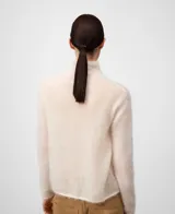 Sweater de punto cardado color negro, con cuello chimenea y manga larga. Confeccionado en una mezcla de mohair y liocel que proporciona ligereza, calidez y un tacto suave. Presenta un diseño minimalista con una caída fluida y brillo sutil.