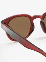 Lentes de sol redondos para niños de 5 a 10 años, con montura color rojo ladrillo y lentes marrones polarizadas.