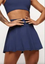 Pollera short deportiva color verde esmeralda, con short interno con bolsillos laterales.