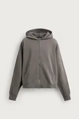 Sudadera con capucha y cierre frontal de cremallera, de color gris con efecto lavado, corte relaxed fit, mangas largas y bolsillos tipo canguro.