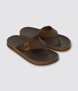 Ojotas masculinas de la marca Cartago, color marrón oscuro con suela marrón claro texturizada. Presentan tiras anchas con textura y un logo de la marca en una de las tiras.